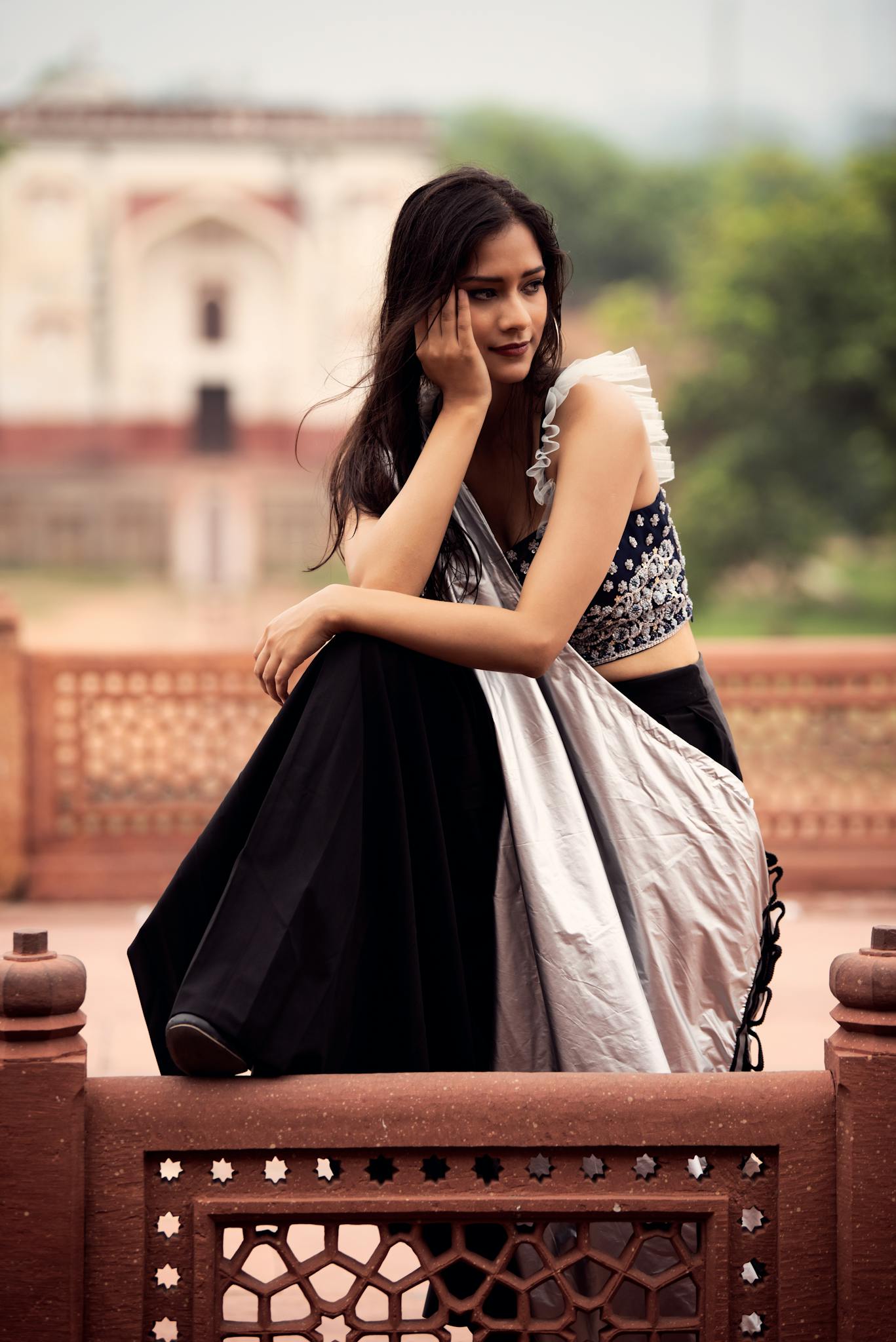 A model posing outdoors in fusion attire, showcasing elegance and style.