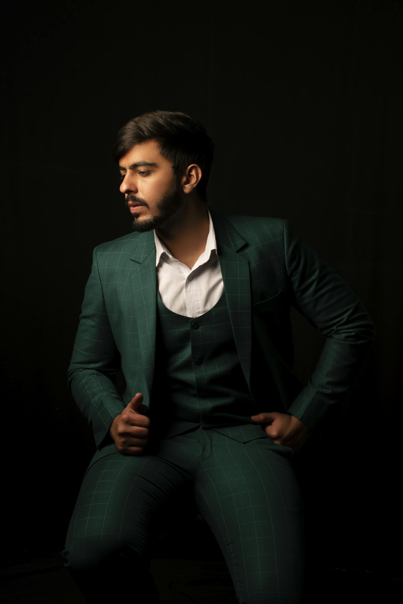 Stylish portrait of a man in a designer green suit. Studio lighting.